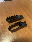 1975 Suzuki TS400 Foot Pegs. OEM.43550-25302/43560-25302 Remanufactured. Price: $72.00.